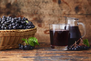 fresh aronia berries and aronia berry juice in glasses