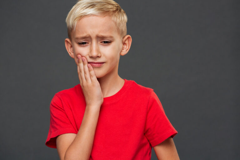 sad little boy child with toothache