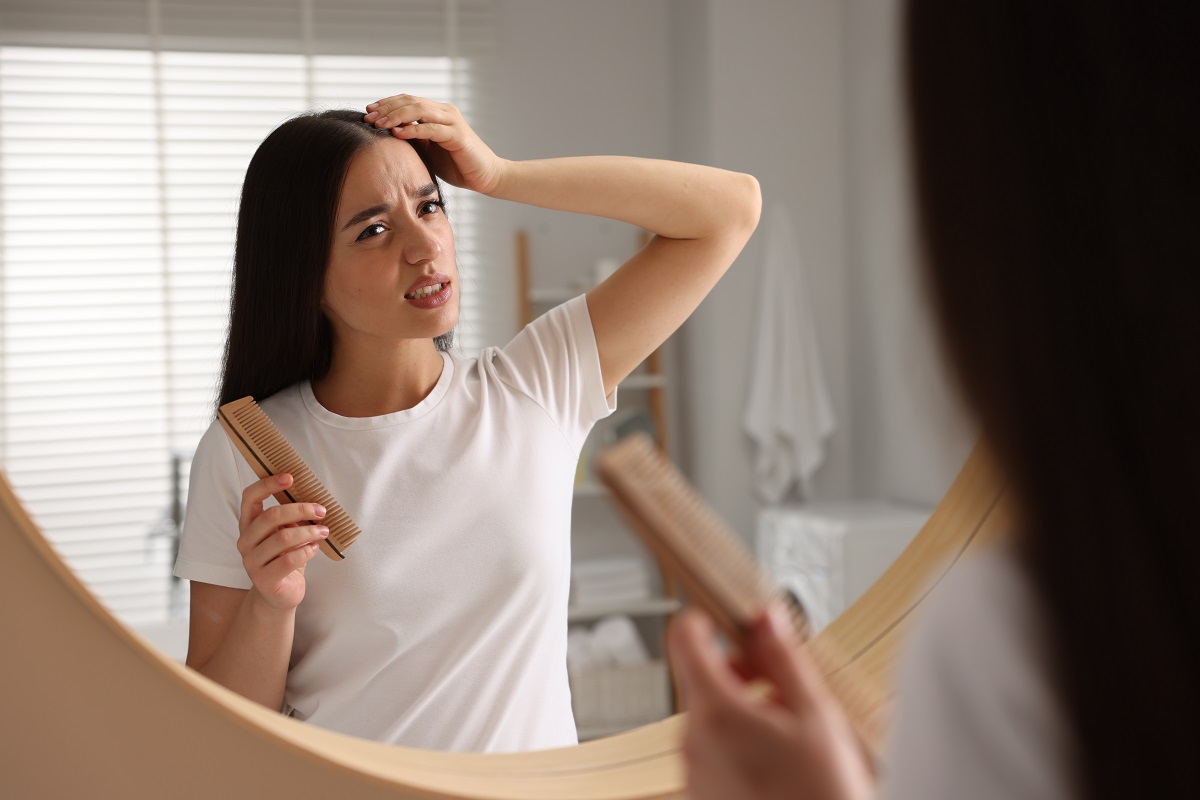emotional,woman,with,comb,examining,her,hair,and,scalp,near
