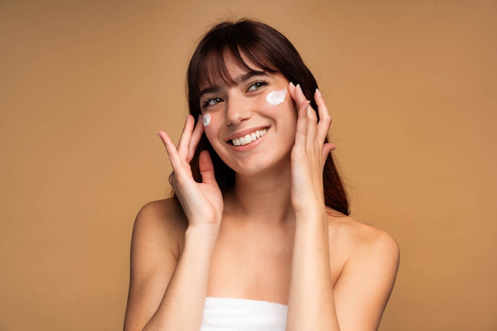 beautiful,young,woman,applying,face,luxury,sunscreen,or,moisturizer,cream